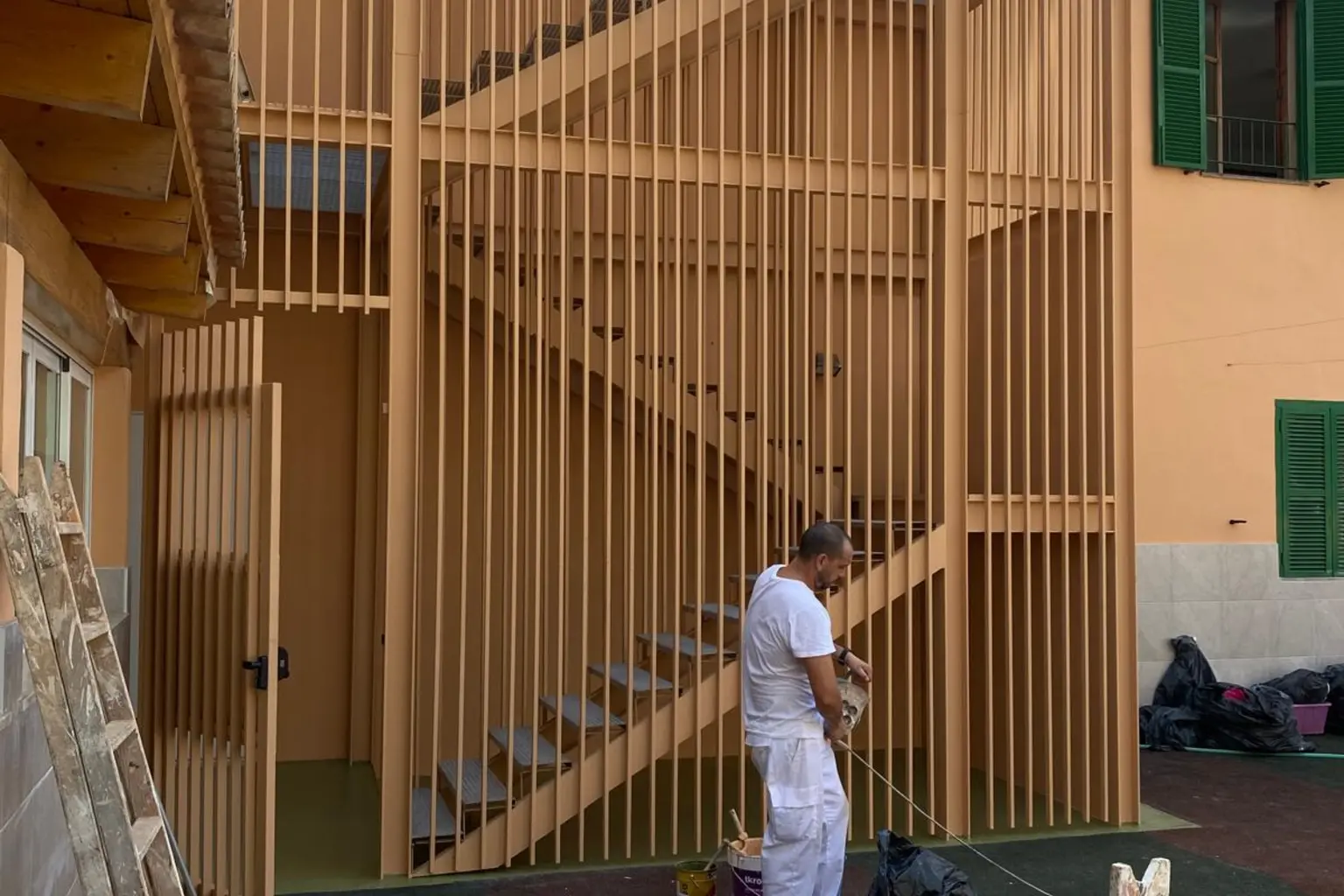 Celosía de lamas de madera lacada en el patio de un centro escolar