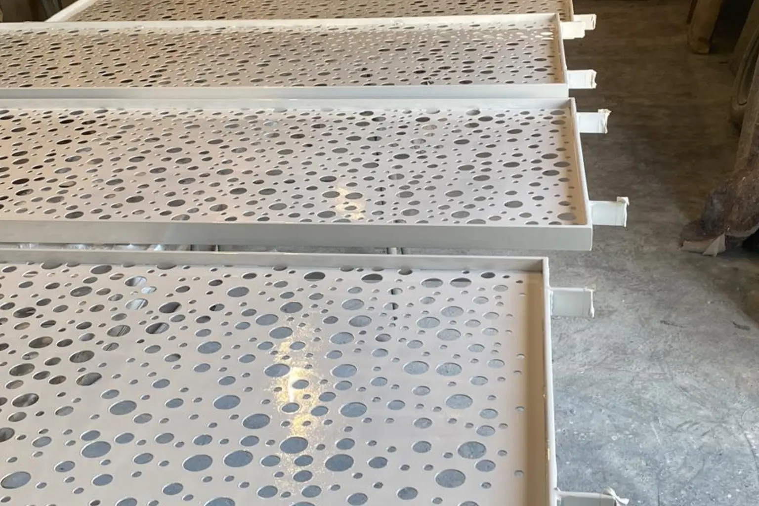 Paneles lacados con un motivo de círculos, extendidos en taller para secar