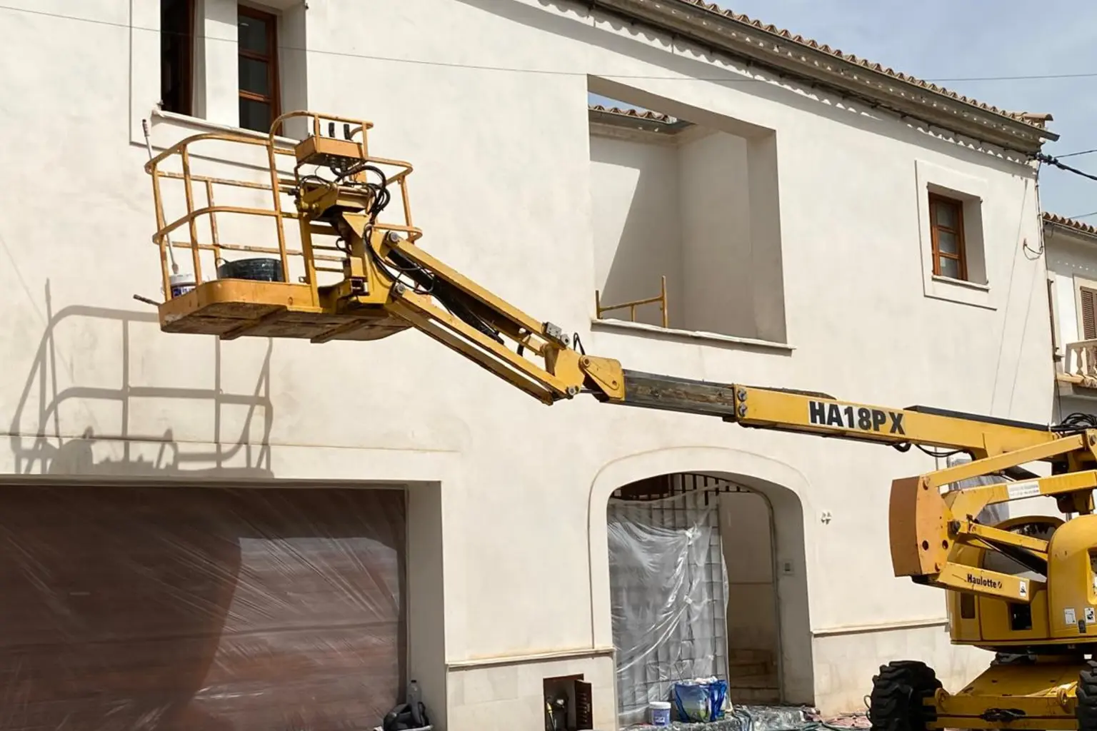 Edificio entre medianeras pintado desde plataforma elevadora articulada