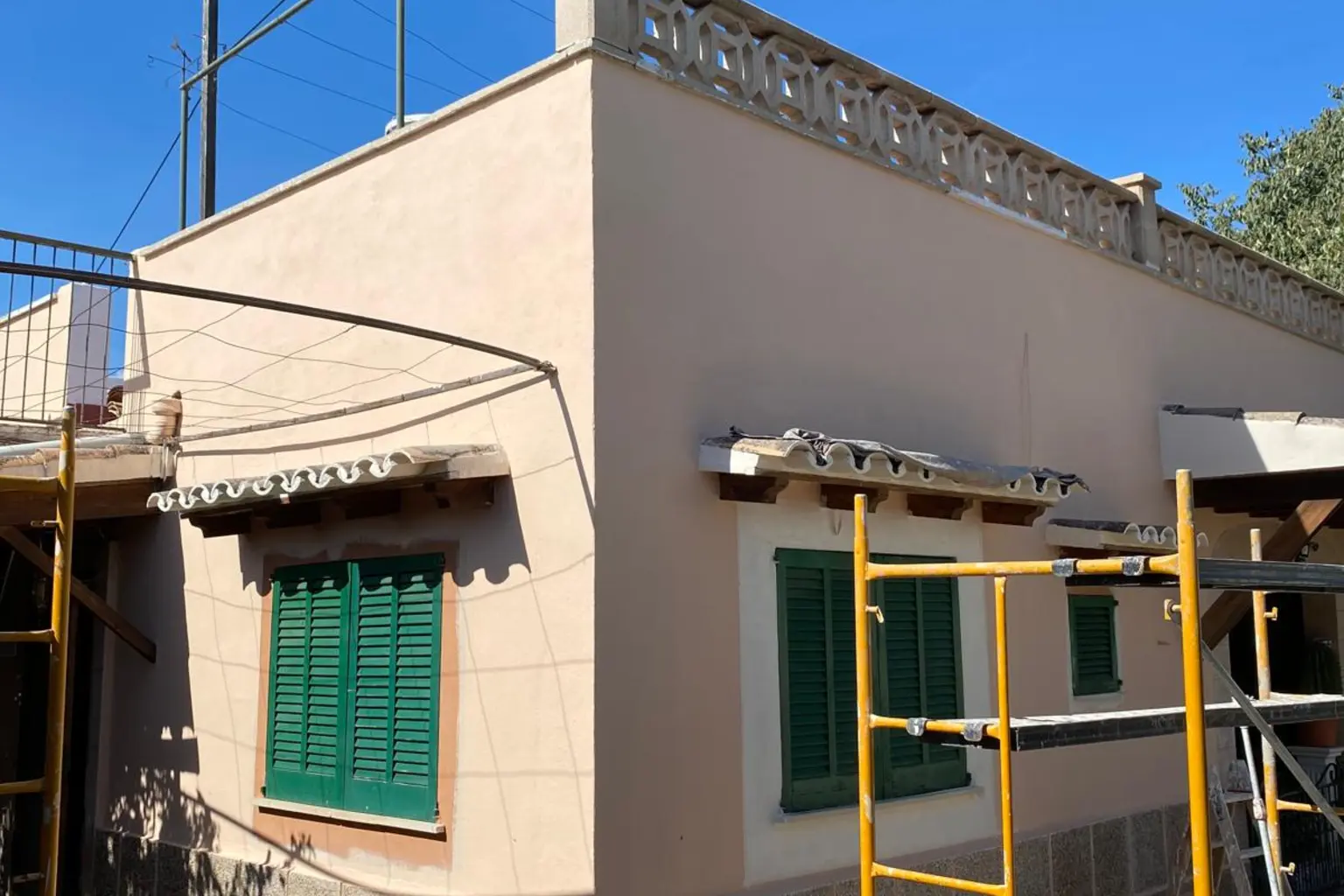 Fachada ya revocada y pintada, con el andamio todavía montado