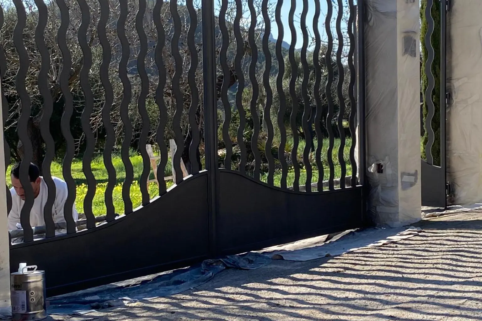 Portón de forja lacado en negro a la entrada de una finca
