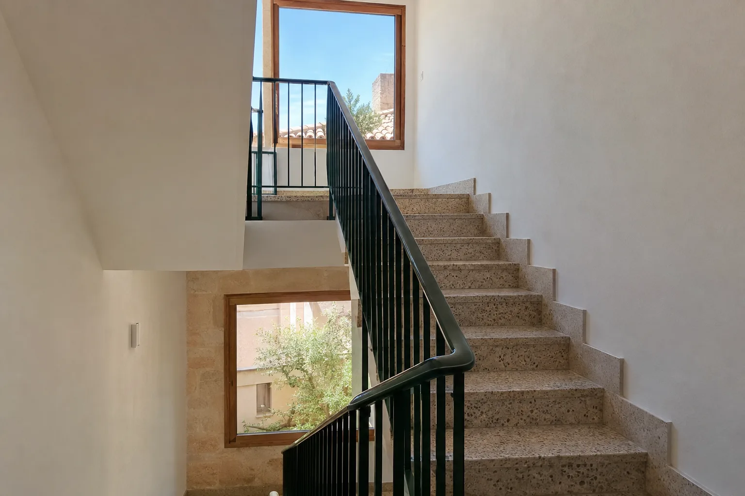 Hueco de escalera de comunidad pintado, con la barandilla esmaltada